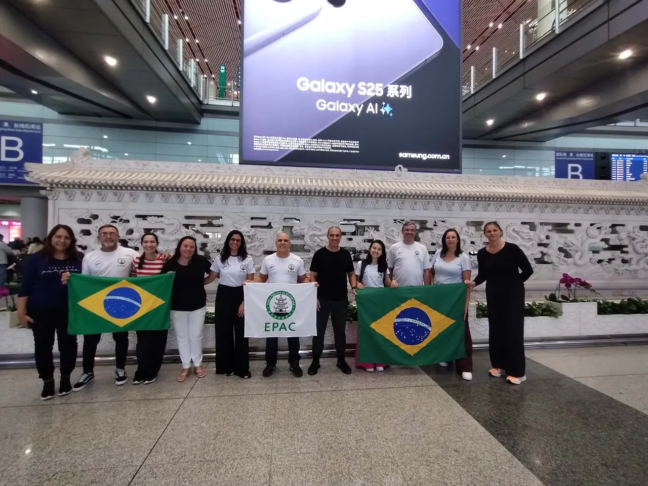 Grupo EPAC com bandeiras do Brasil no aeroporto, no embarque